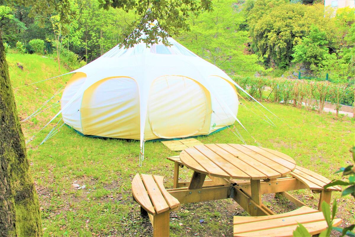 Een tent met een picknicktafel ervoor.
