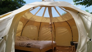 A tent with a bed, a small table, and a chair inside. - Le Moulin Du Luech - Bulles Insolites (Peyremale)