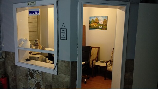 Ein Zimmer mit einem Fenster, das eine Hundefigur und ein Schild mit der Aufschrift 'RESPECT YOUR SPACE' zeigt. An der Wand hängt ein Schild mit der Aufschrift 'Don't Worry, Be Happy'.