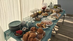 A buffet table with various food items and condiments, including pastries, bread, and beverages. - Nautilus B&B Suite Design (Follonica)