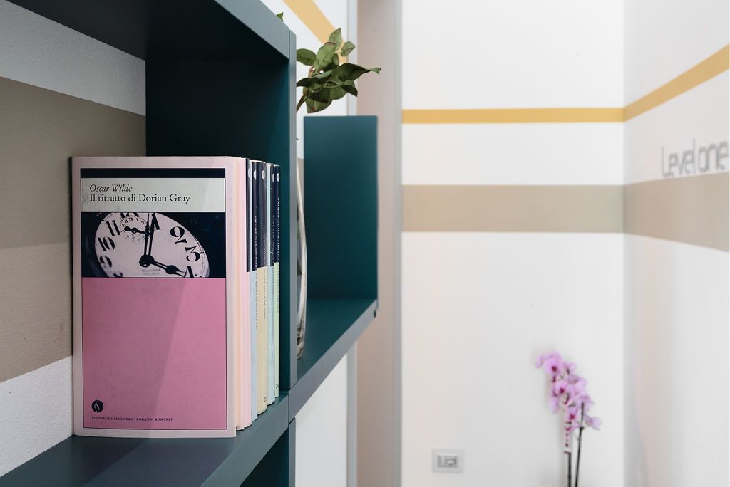 A bookshelf with a book titled 'Il ritratto di Dorian Gray' by Oscar Wilde.