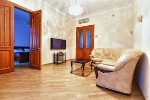 Relax in this inviting living room with a sofa, coffee table, and TV on a stand.
