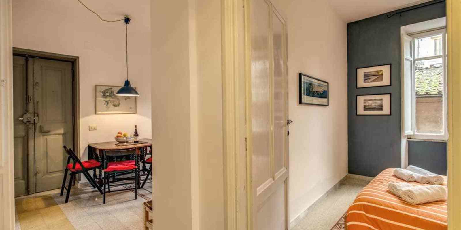 Une pièce avec un lit, une table et des chaises, et une fenêtre.