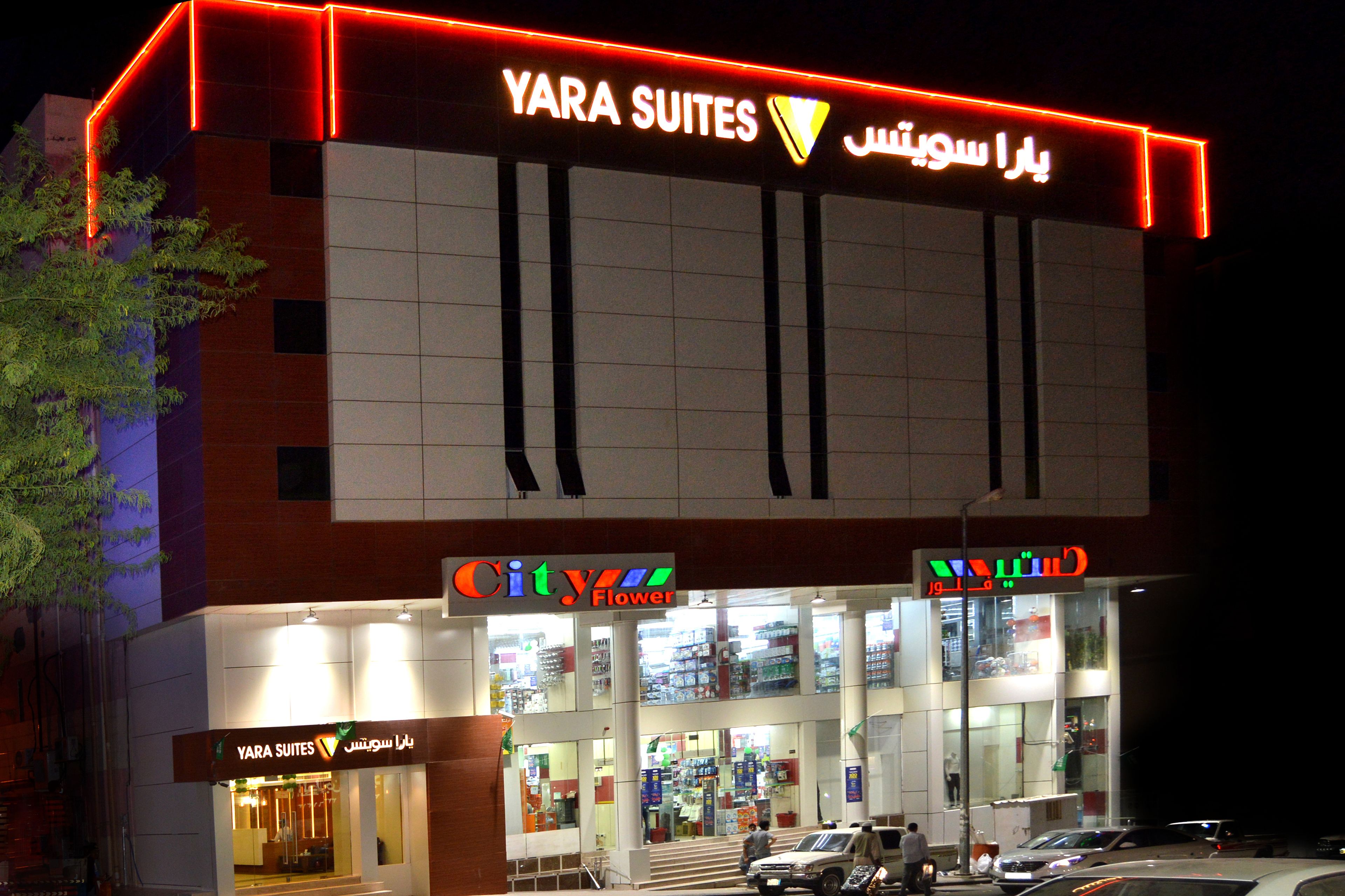 Un hotel con un letrero que dice 'YARA SUITES' y 'City Flower' en su fachada.