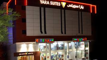 Un hotel con un letrero que dice 'YARA SUITES' y 'City Flower' en su fachada.