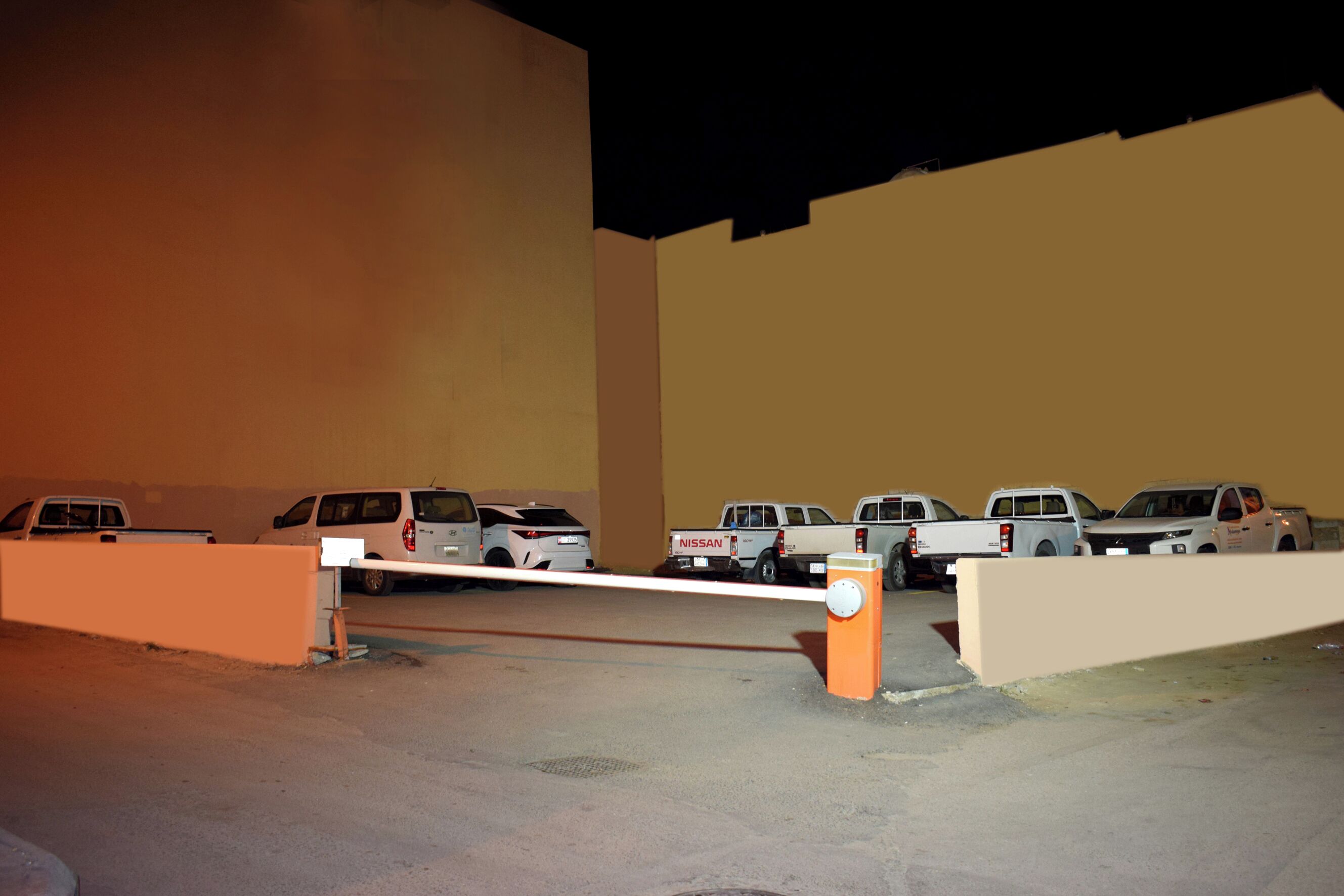 Un área de estacionamiento con varios vehículos, incluyendo camiones y furgonetas, en un espacio interior con pisos y paredes de concreto.