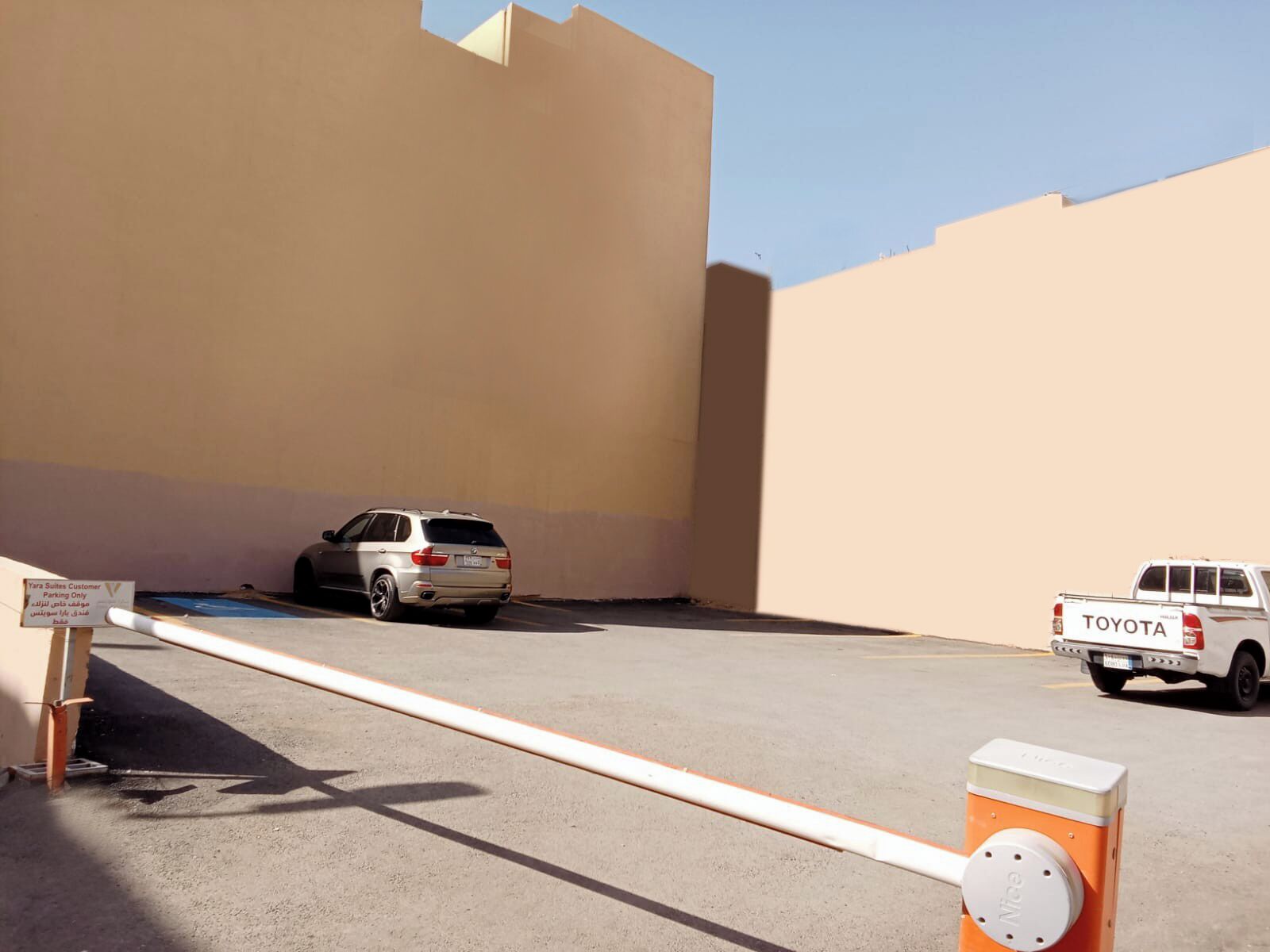 A parking area with a white SUV and a white pickup truck.