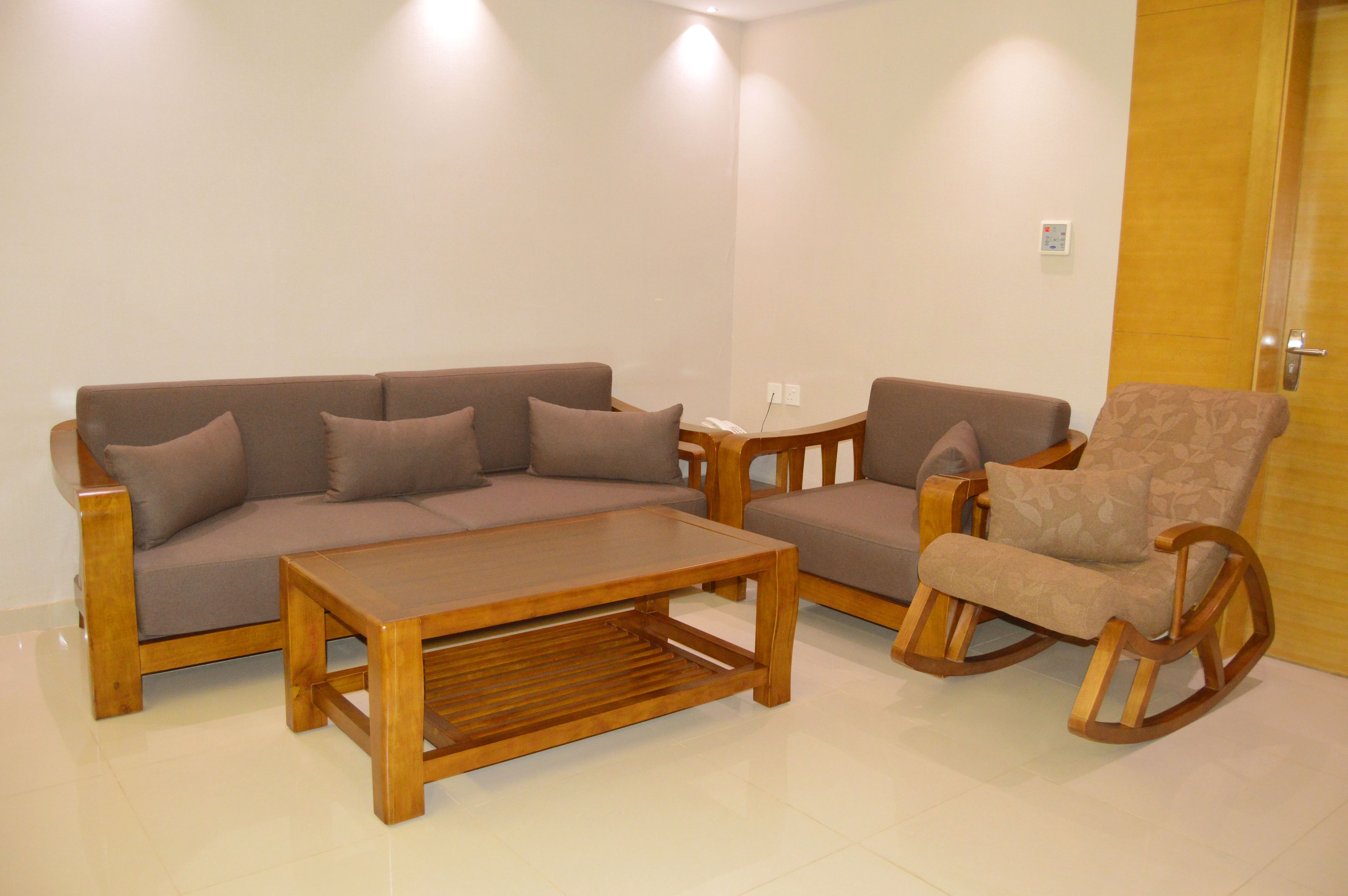 Una sala de estar con un sofá, una mesa de centro y un sillón mecedora.