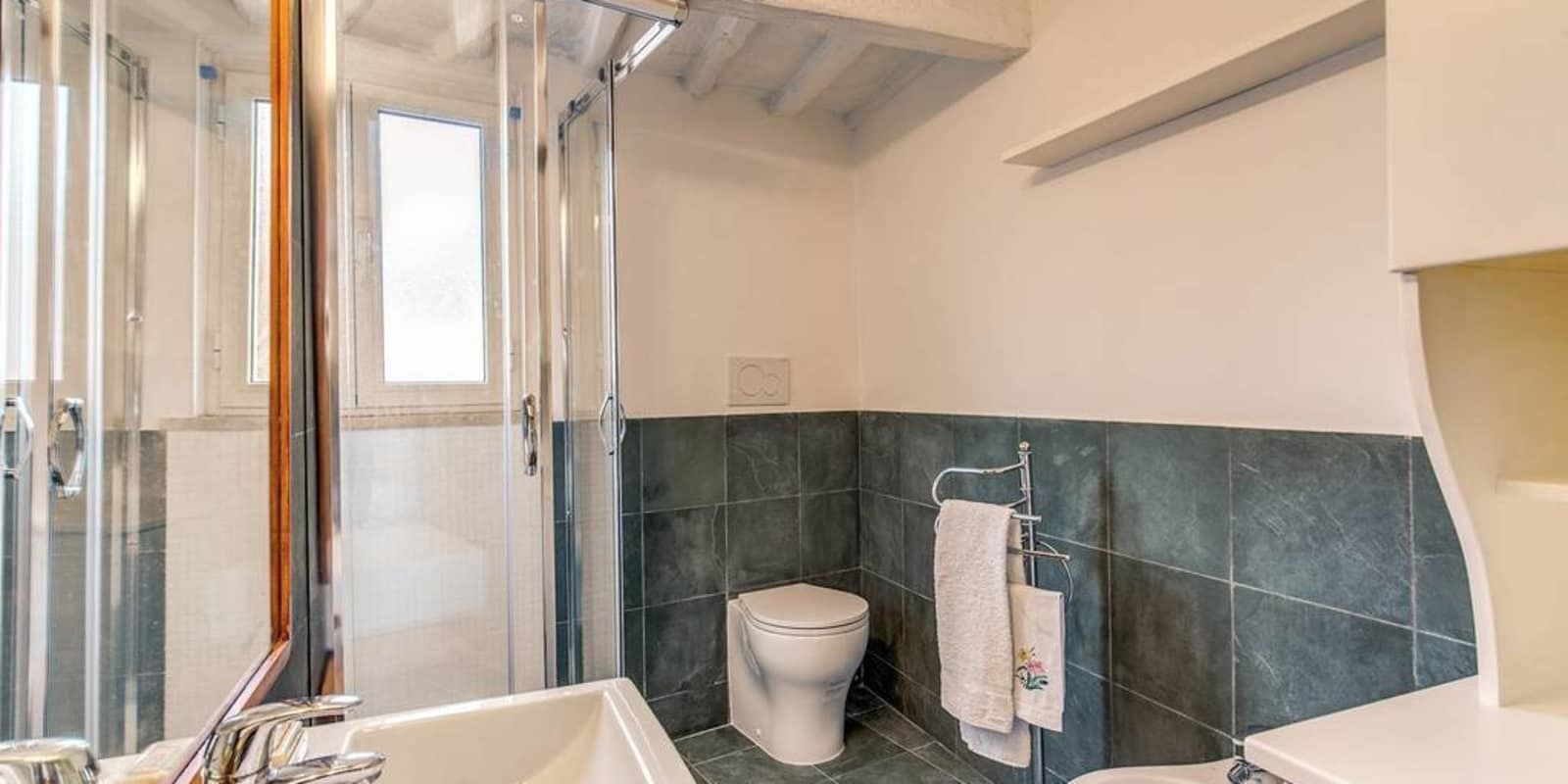 A bathroom with a glass shower enclosure, a white toilet, and a bathtub.