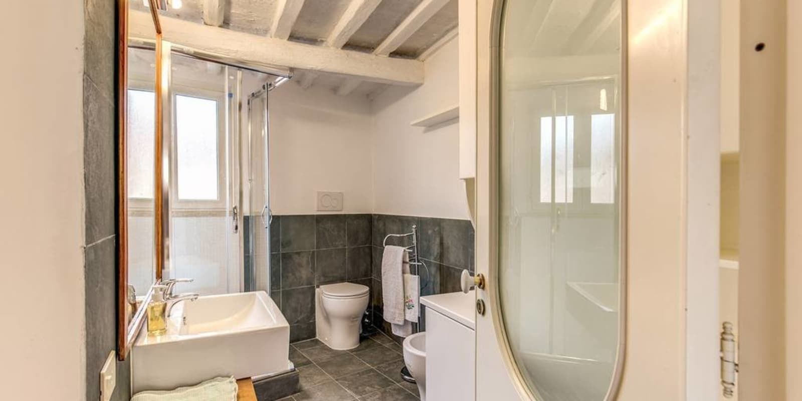Et badeværelse med badekar, toilet og bruseområde.