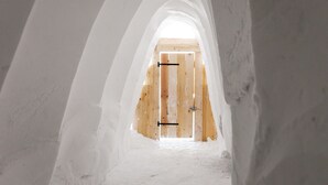 Una habitación en el ático con una puerta de madera y techo inclinado.