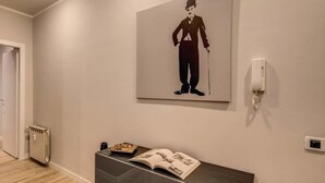 Un couloir avec un radiateur, un téléphone et une œuvre d’art encadrée accrochée au mur.