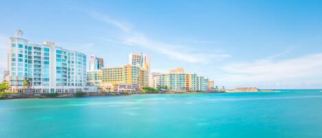 Un hotel costero con varias edificaciones, vista despejada al océano y el logotipo de Condado Lagoon Hospitality.