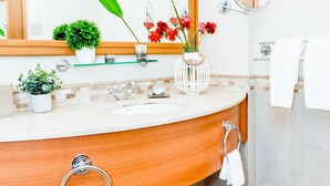 A bathroom with a wooden vanity, a mirror, a sink, and a towel rack. - 827 Sea and Sun Studio (San Juan)