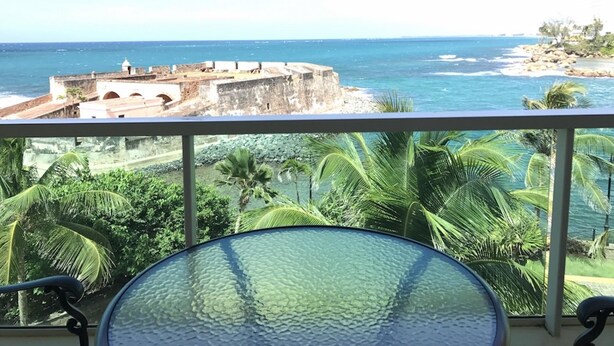 A balcony with a view of a coastal fort and ocean. - 510 Ocean Studio (San Juan)