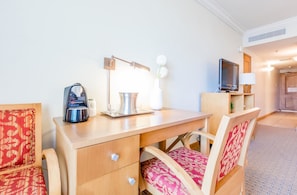 Relax in this stylish room with a desk, two chairs, and a mounted TV.