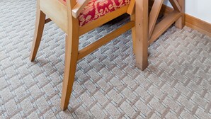A small wooden table with a lamp, a chair with a patterned cushion, and a small potted plant. - 619 Breezy Studio (San Juan)