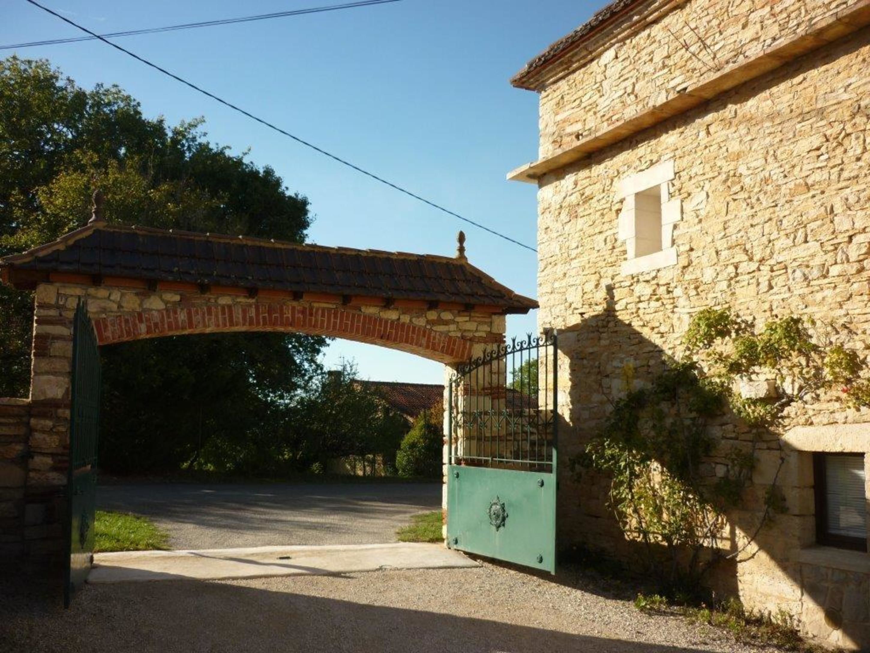 Un edificio de piedra con una entrada porticada y un arco cubierto.