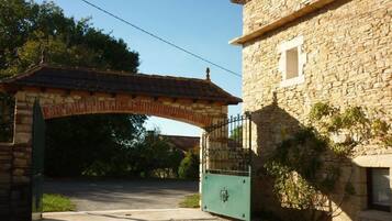Un edificio de piedra con una entrada porticada y un arco cubierto.