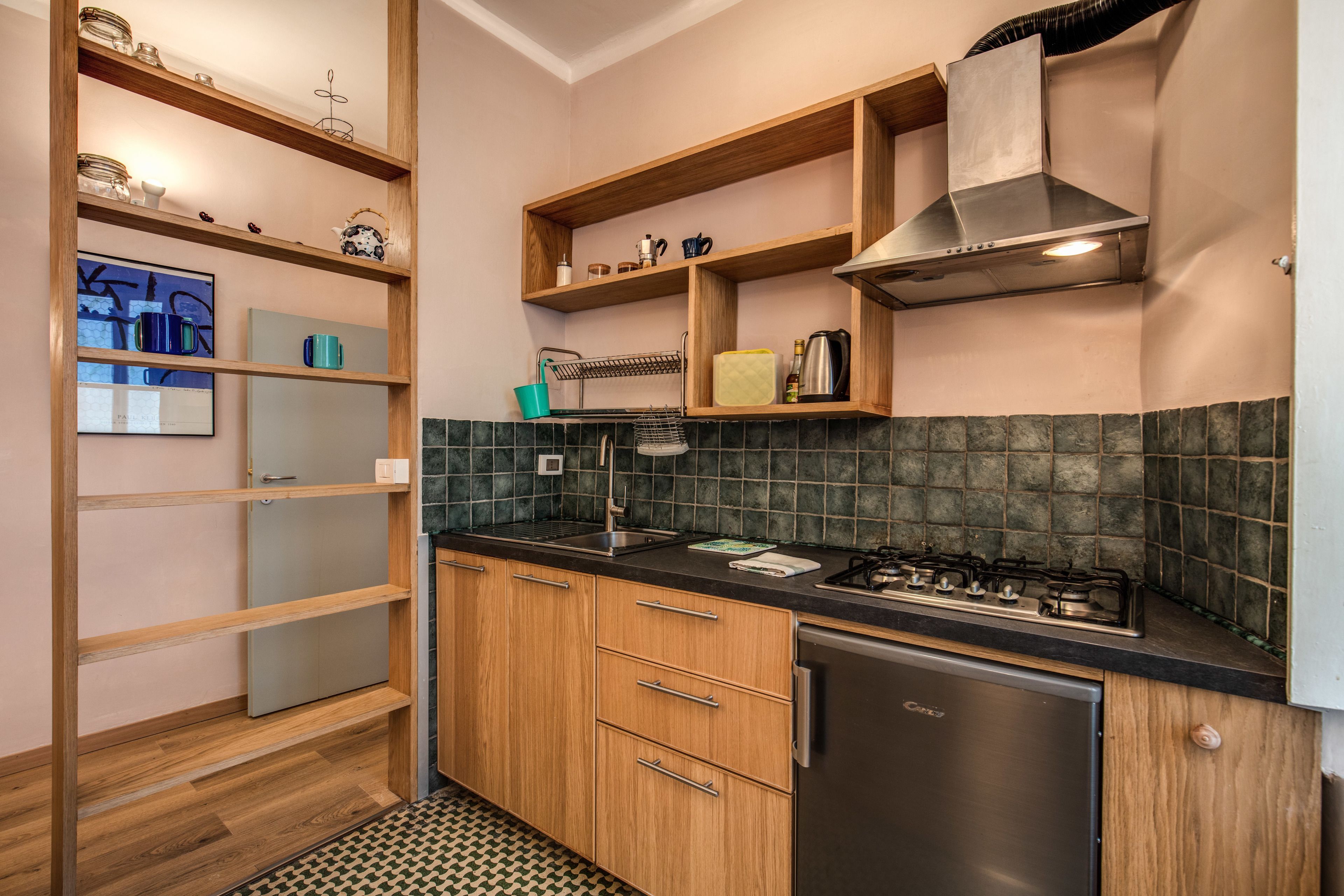 A compact kitchen with wooden cabinets, a built-in stove, and a dishwasher.