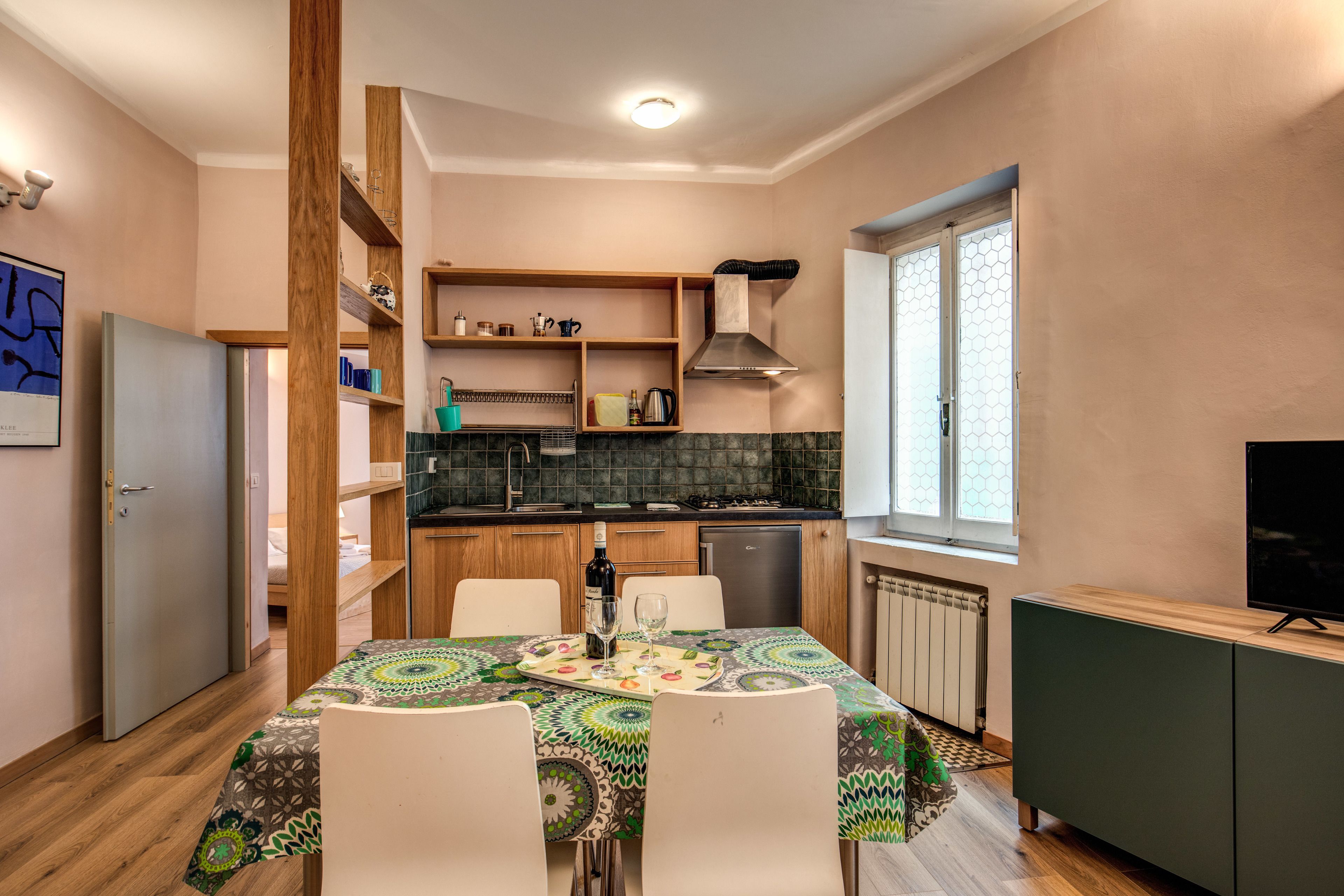 A compact kitchen with wooden cabinets, a built-in stove, and a window.