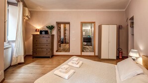 Una camera da letto con un letto, una cassettiera, un armadio e un bagno visibile attraverso una porta.