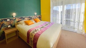 Een slaapkamer met een bed, nachtkastje en een raam met gordijnen.