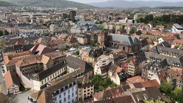 A densely packed urban area with historic buildings, a prominent church, and a view of distant hills.