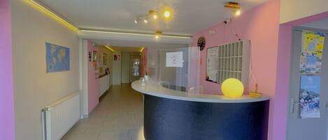 A reception area with a curved counter, a map on the wall, and a clock.