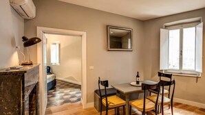 A dining area with a table, chairs, and a window. - Cappellari 4 Campo de Fiori (Rome)