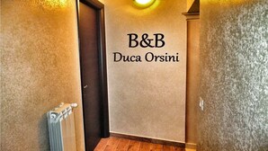 A hallway with a sign reading "B&B Duca Orsini" on the wall. - B&B Duca Orsini (Gravina in Puglia)