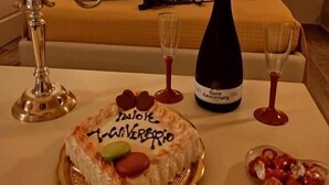 A hotel room with a bed, a table with a cake, a bottle of wine, and heart-shaped balloons. - B&B Duca Orsini (Gravina in Puglia)