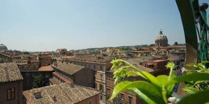 A cityscape with historic buildings and a prominent dome structure in the background. - Exclusive Terrace Largo Argentina (Rome)