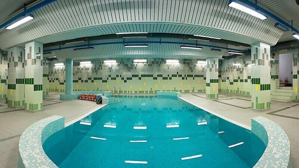 An indoor swimming pool with a tiled floor and walls, surrounded by columns and a tiled ceiling. - Hotel Villa Plinia (Pragelato)
