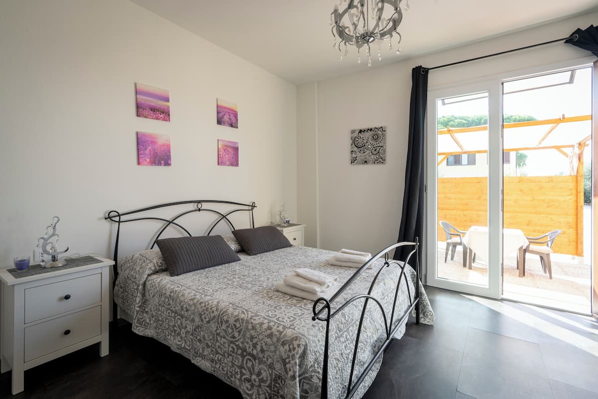 Ein Schlafzimmer mit einem Bett, einem Nachttisch und einem Kunstwerk an der Wand.