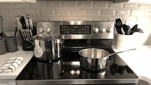 A stainless steel stove with pots and a digital control panel. - Exclusive One Bedroom Suite (Boston)