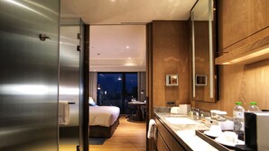 A modern hotel room with a large bed, a desk, and a bathroom with a large mirror and sink. - DoubleTree by Hilton Taipei Zhongshan (Taipei)