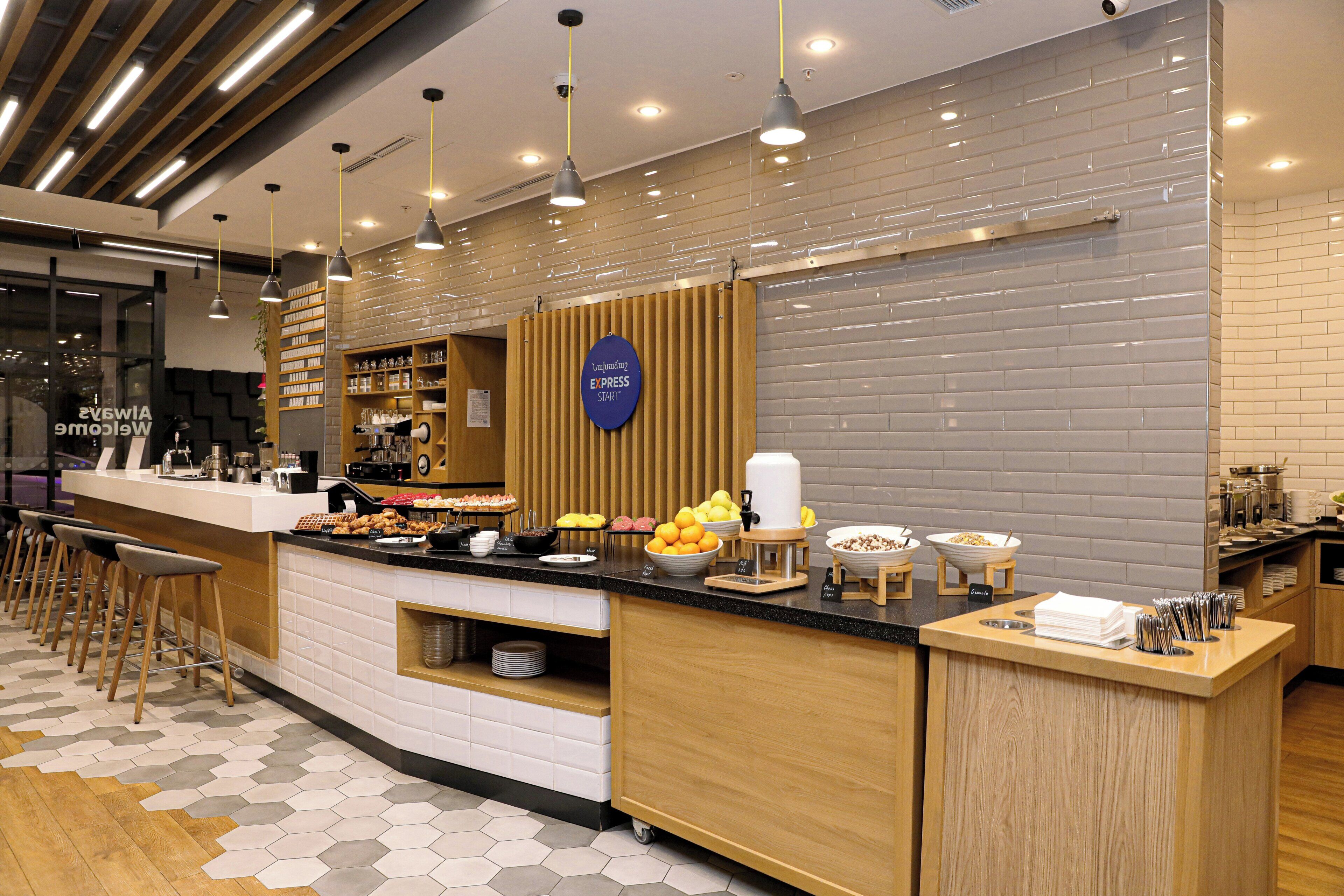 Una barra de desayuno moderna con diversos alimentos y una estación de café.