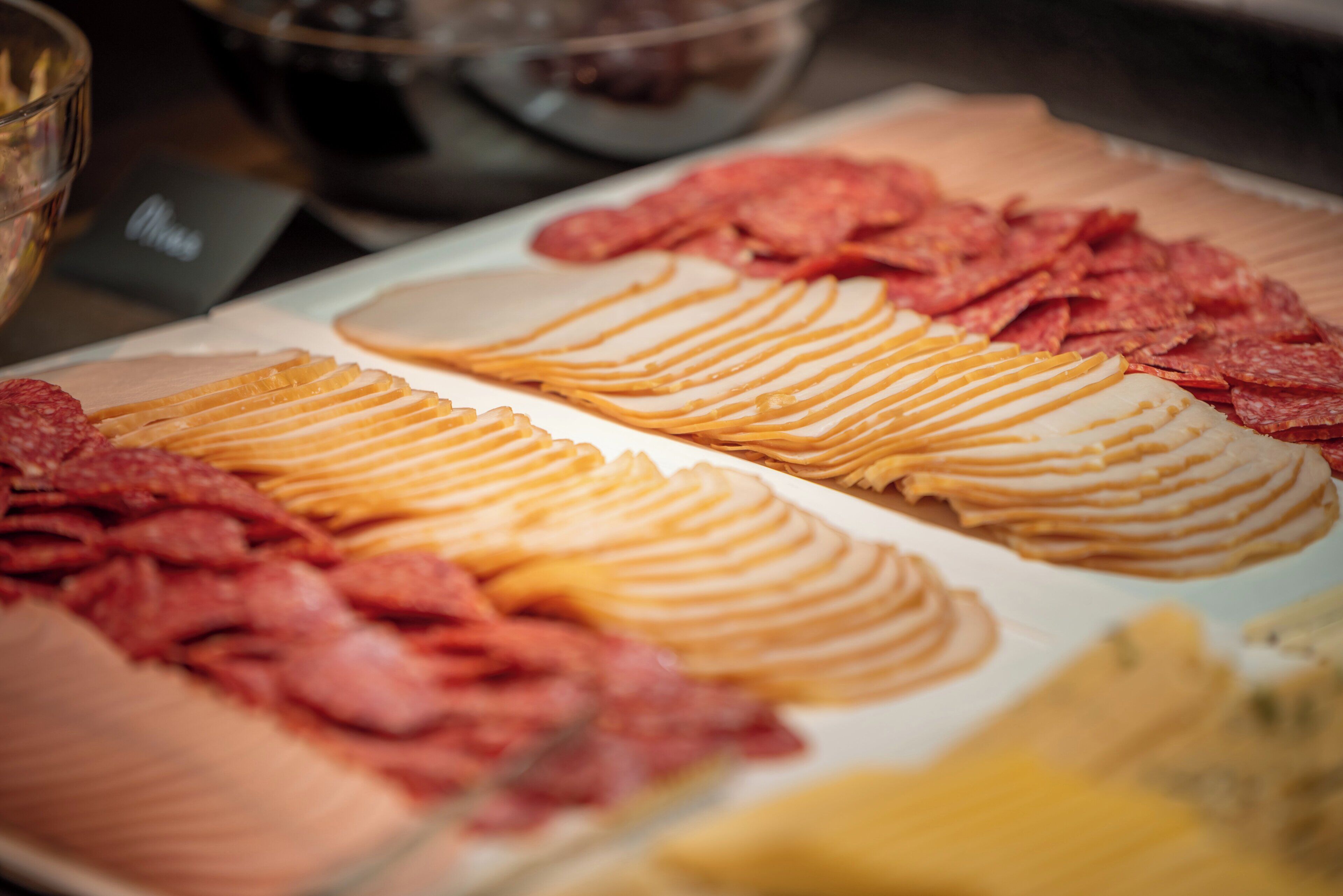A buffet with various food items including sliced meats and cheeses.