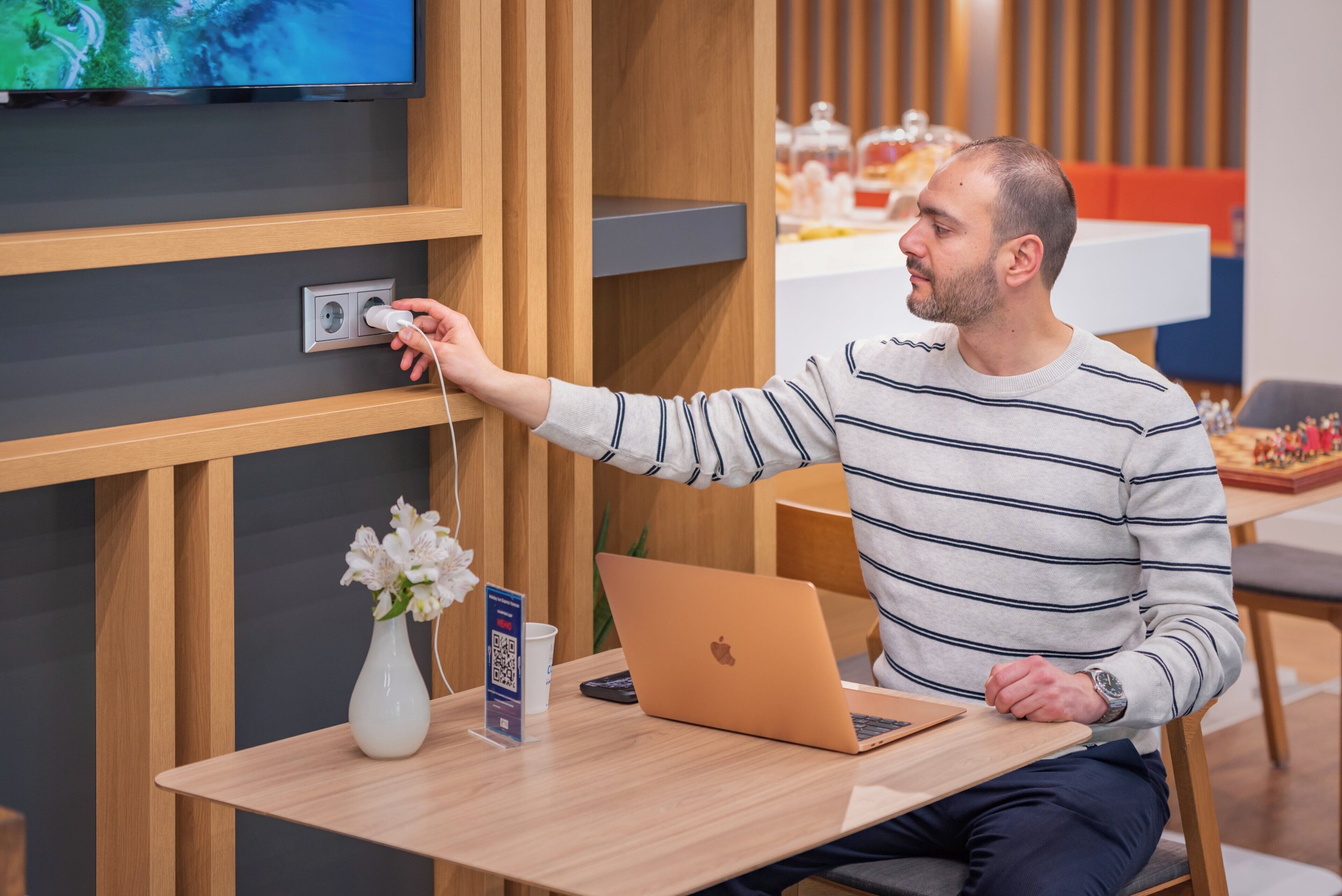 A person plugging in a device into a wall socket.