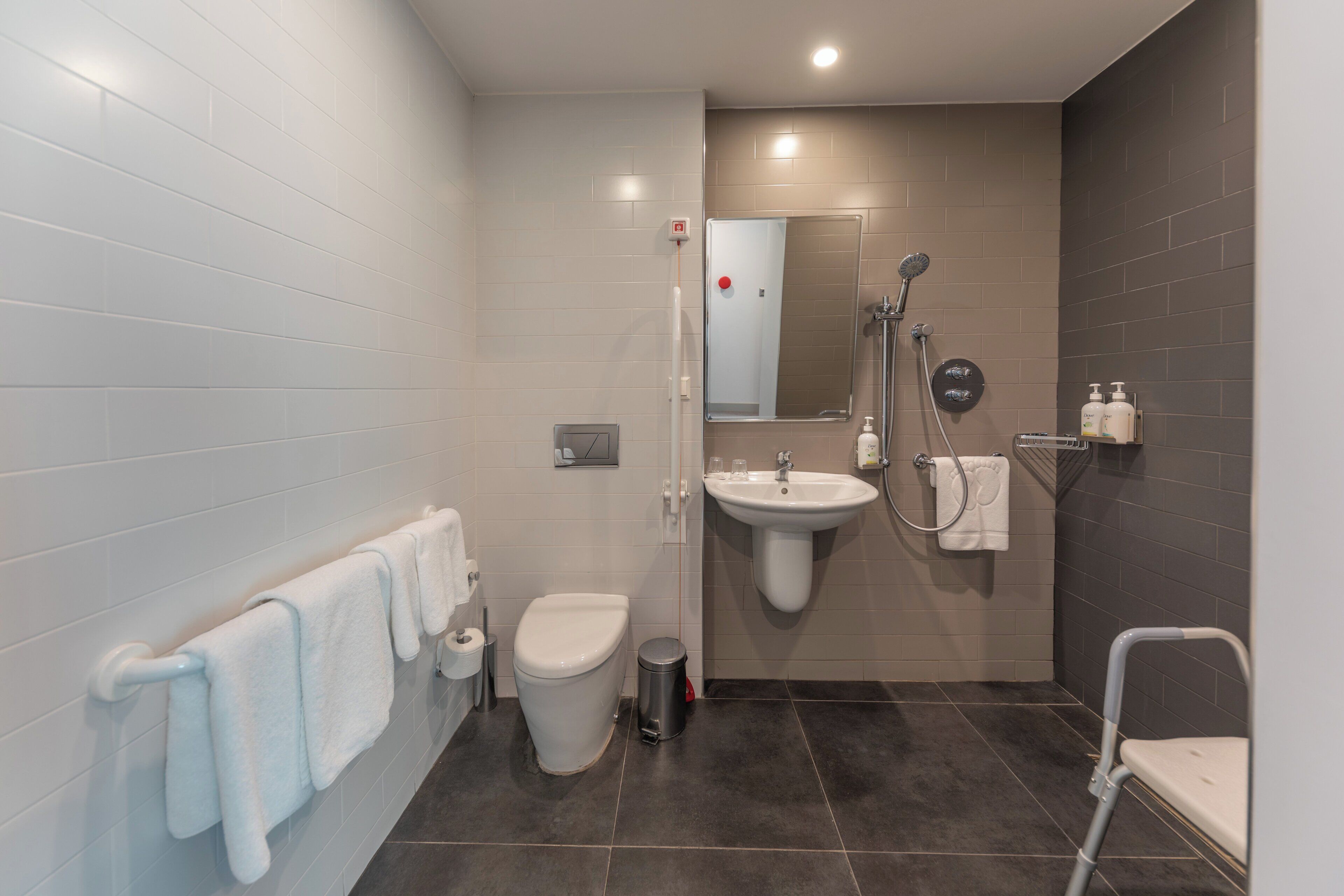 A modern bathroom with a toilet, sink, and shower.