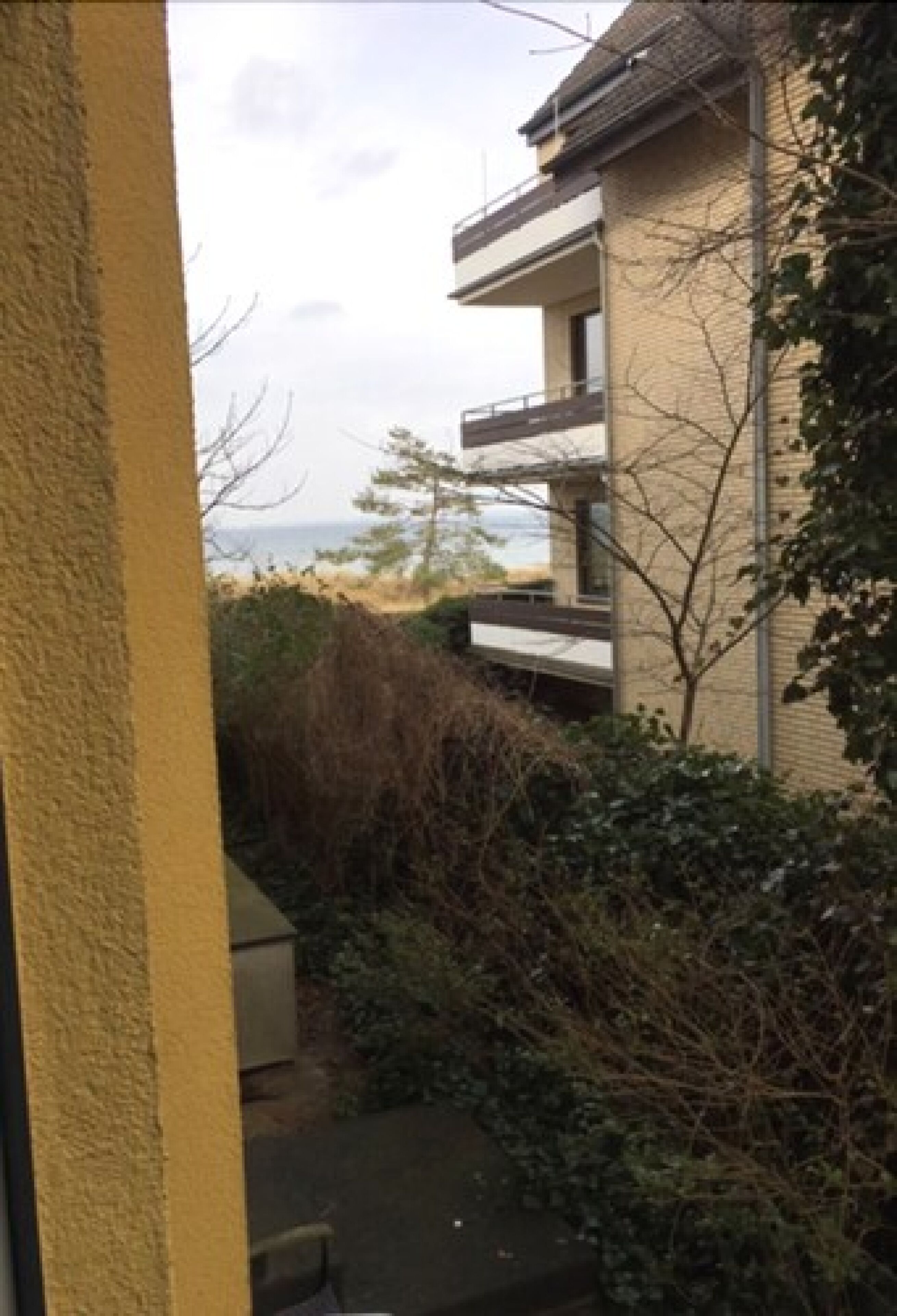 A building with a balcony overlooking a beach.