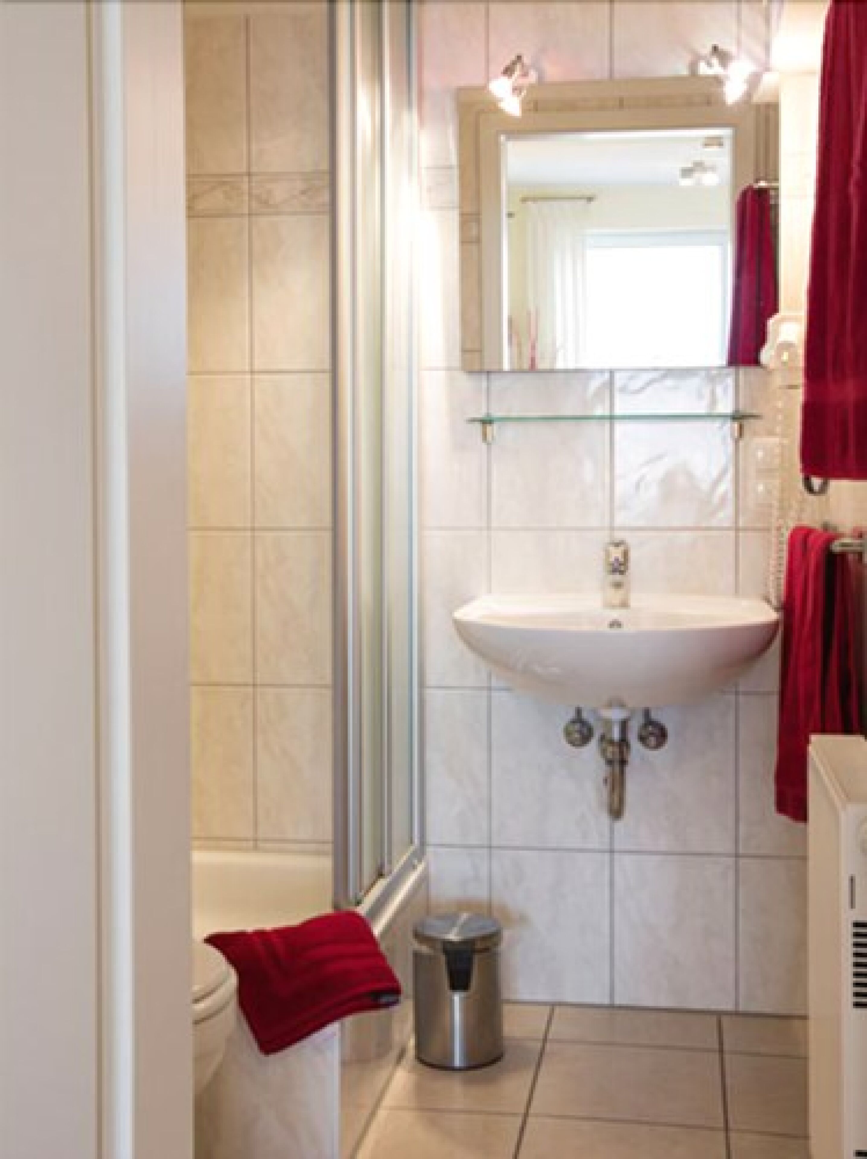 Een badkamer met een douche, wastafel en toilet.