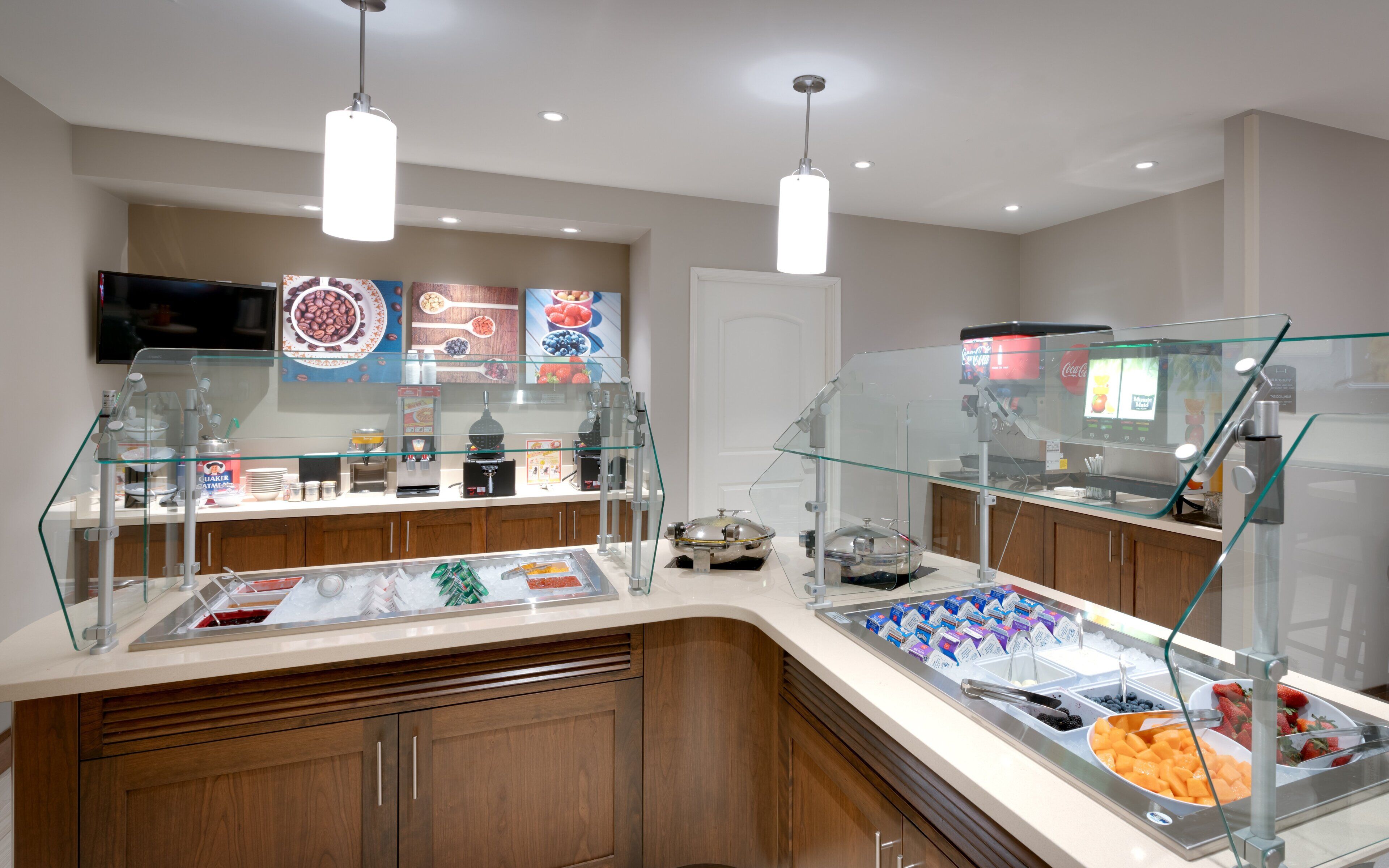 A buffet area with a variety of food options, a coffee machine, and a Coca-Cola refrigerator.