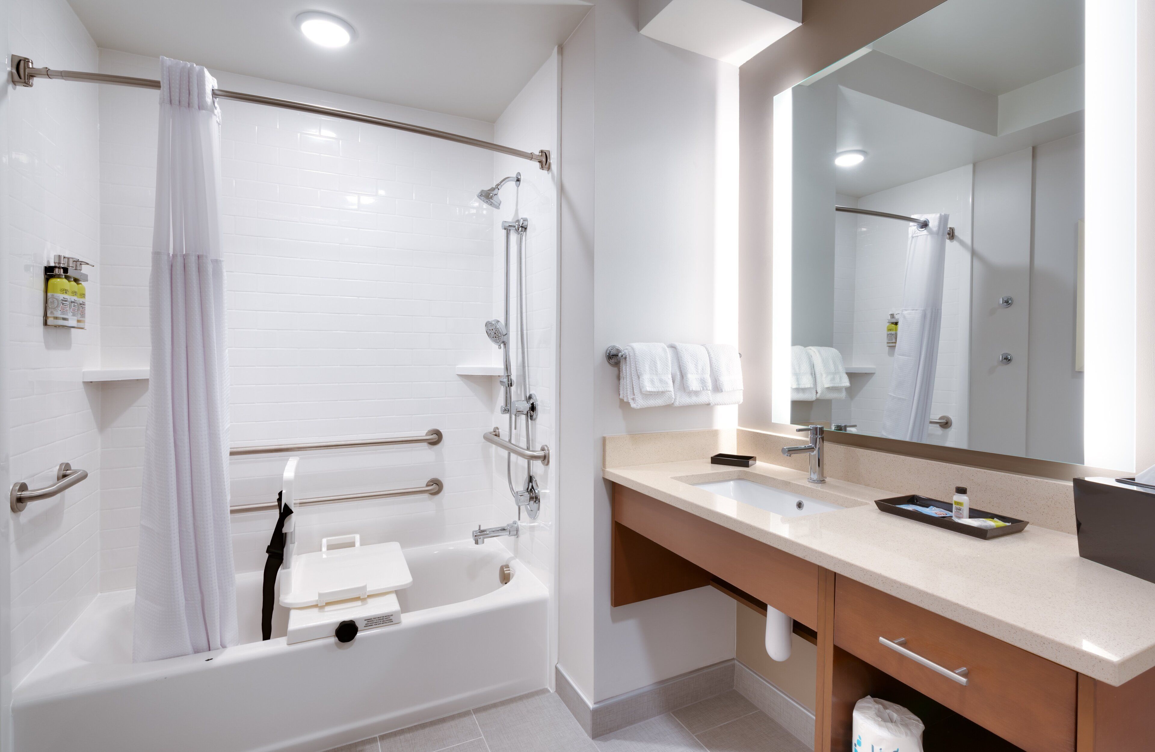 Une salle de bain moderne avec une baignoire, une douche, un meuble-lavabo et un grand miroir.