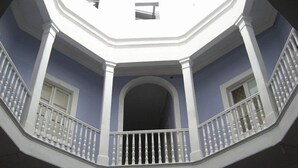 A corner of a building with a white balcony railing and a blue wall. - Hotel Garden (Valparaiso)