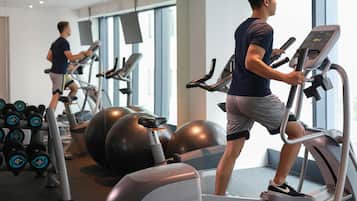 A gym with treadmills, exercise balls, and dumbbells.
