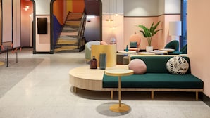 Ein modernes Interieur mit einer Treppe, einem grünen Sofa und einem runden Tisch.