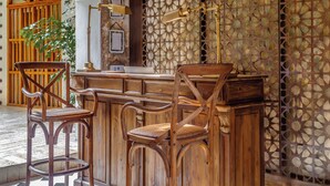 A bar area with wooden chairs and a bar counter. - Hotel Casa La Factoria by Faranda Boutique, a member of Radisson Individuals (Cartagena)