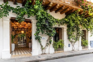 A building with a balcony, a sign reading 'SAFARI LA FACTO,' and a tiled entrance.